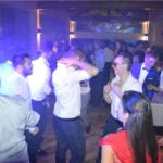 Invitati che ballano tra luci blu durante una festa di matrimonio animata dal DJ.