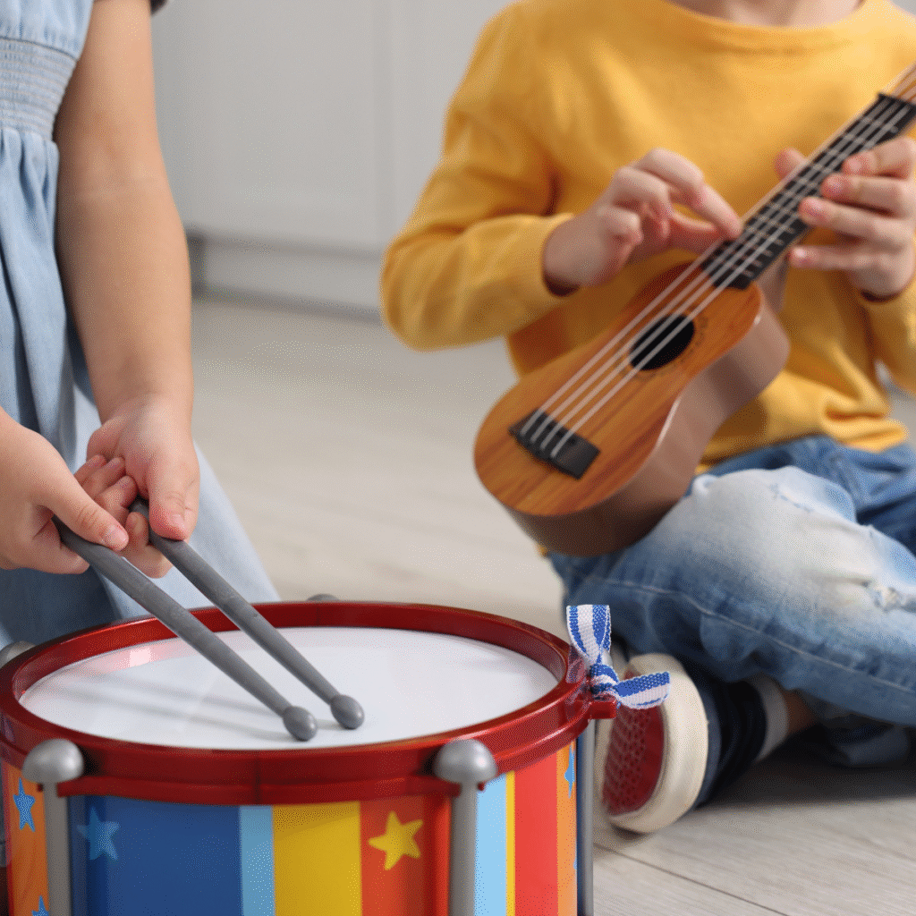Intrattenimento per bambini: giochi, musica e divertimento per feste indimenticabili in Veneto Bambini che suonano tamburo e ukulele durante un’attività musicale educativa.