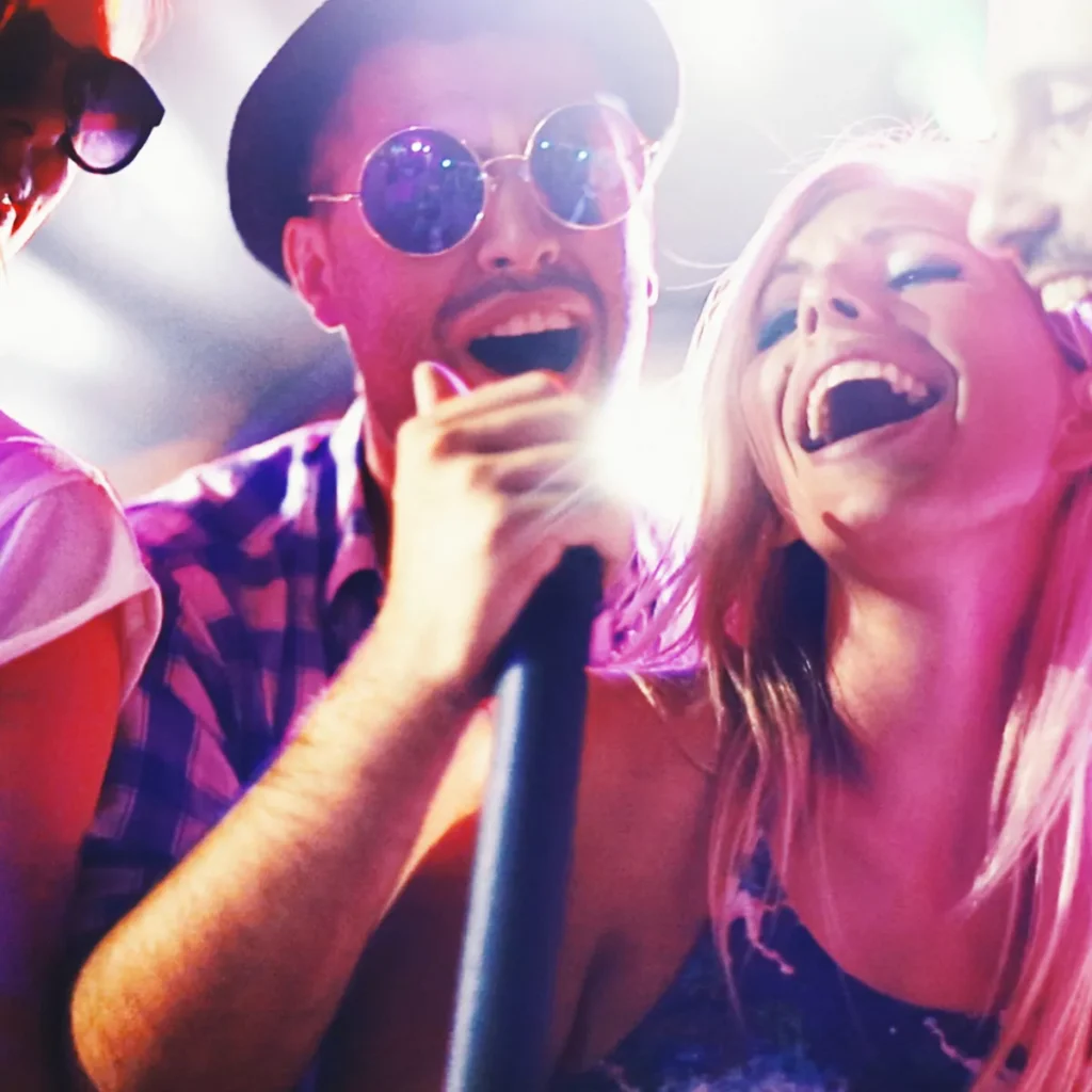 🎤 Karaoke per Eventi e Feste Amici che cantano al karaoke con microfono a una festa vivace.