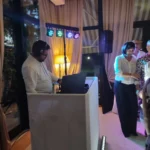 DJ alla consolle con luci colorate e ospiti che ballano durante il ricevimento.