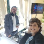 DJ e cantante sorridenti accanto alla consolle durante l’animazione musicale del matrimonio.